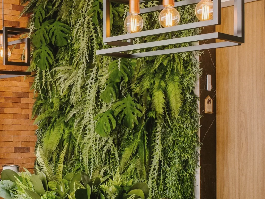Sala de reuniones con mesa de madera y pared vegetal